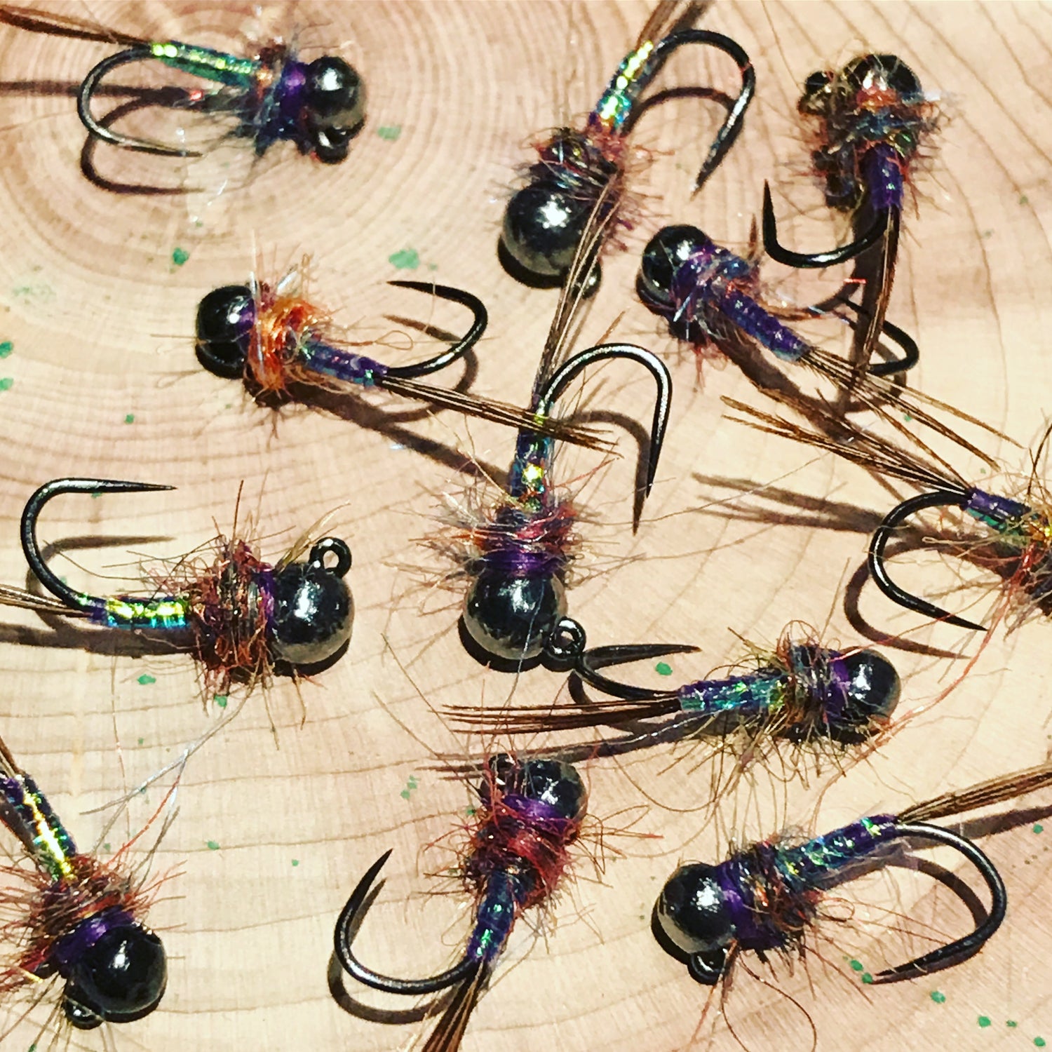 A dozen purple reign trout flies on barbless jigged hooks